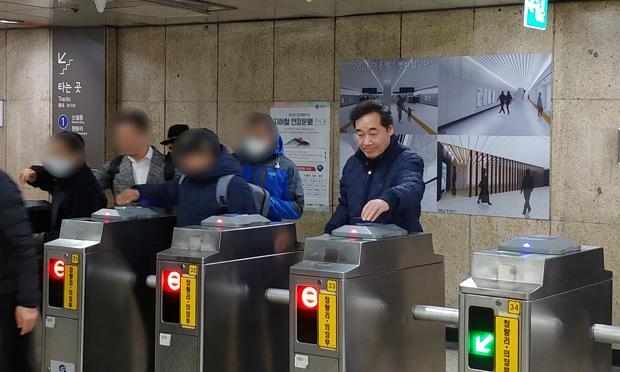이낙연이 서민들을 응시하지 않은채 홀로 왼쪽에 교통카드를 태그하여 지하철을 한번도 안타봤음을 보여주고 있다.
